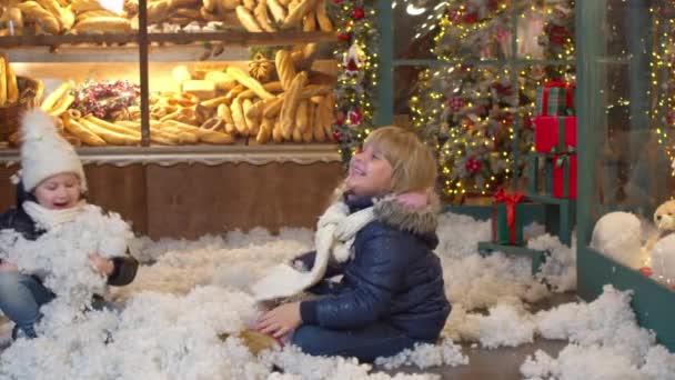 Boldog gyerekek játszanak mesterséges hó együtt — Stock videók