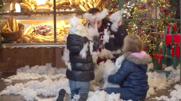 Kinderen gooien nep sneeuw naar vader in kerstavond — Stockvideo