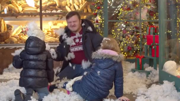 Niños lanzando nieve falsa al padre en la noche de Navidad — Vídeos de Stock