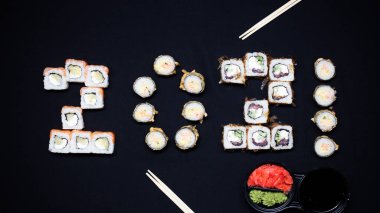 2021 'in karanlık arka planında lezzetli suşili kompozisyon.