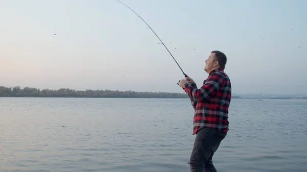 Pescador masculino tomando selfie con peces cerca del agua — Foto de Stock