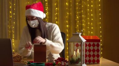Kadın Noel hediyesini paketlerken salgın sırasında görüntülü konuşma yapıyor