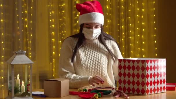 Mujer en la máscara de embalaje presenta en colorida caja de Navidad — Vídeos de Stock
