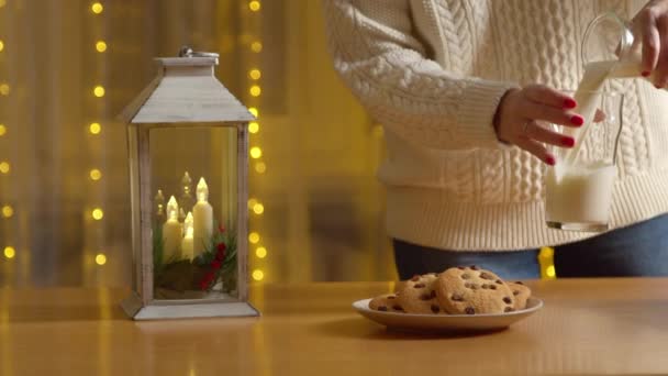 Женщина-растительница готовит молоко и печенье для Санта-Клауса — стоковое видео