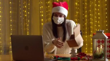 Kadın Noel hediyesini paketlerken salgın sırasında görüntülü konuşma yapıyor