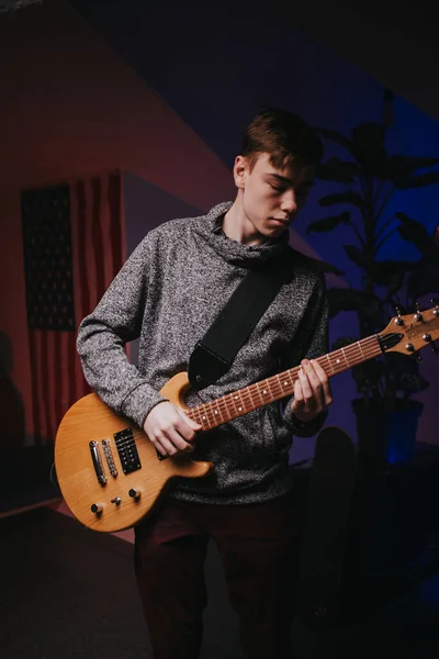 Gitarla rock çalan enerjik genç bir adam.