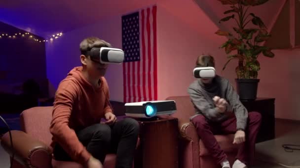 Молодые люди в наушниках вместе играют в виртуальные видеоигры — стоковое видео