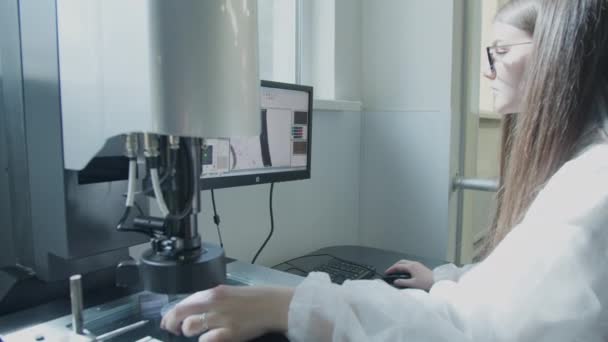Вчений, що працює з мікроскопом у виробничій лабораторії — стокове відео