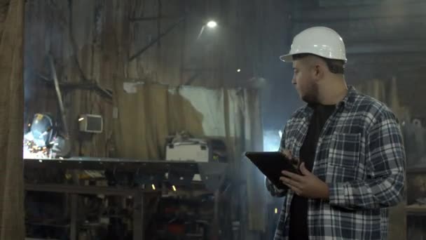 Plump empleado masculino usando tableta en taller de fábrica — Vídeo de stock