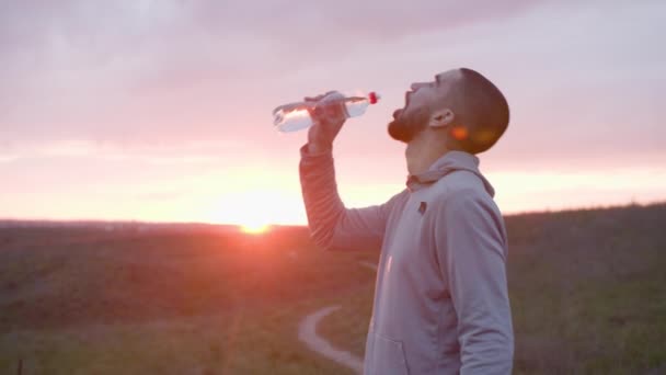 Corredor de água potável após o treino no campo — Vídeo de Stock