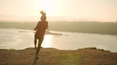 Aktif kadın gün batımında dövüş egzersizleri yapıyor.