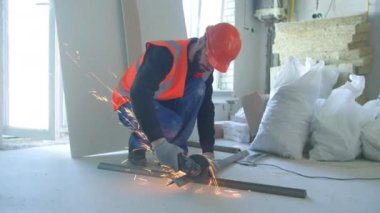 Erkek müteahhit iş sırasında metal parçaları kesiyor