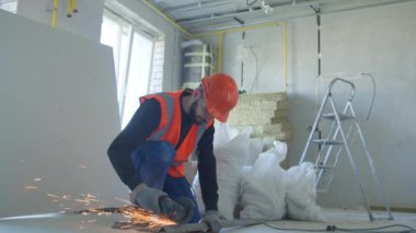 Erkek müteahhit iş sırasında metal parçaları kesiyor