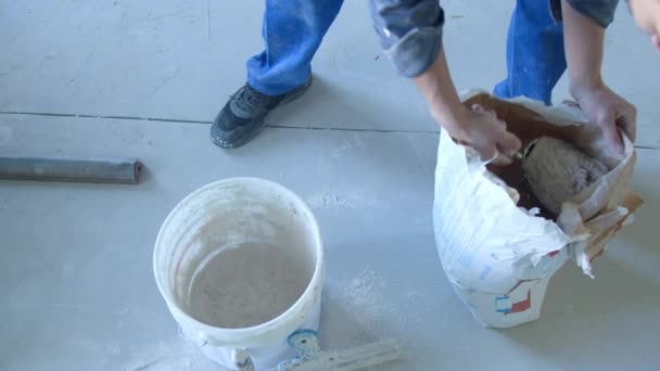 A worker kneads the mixture into plaster buckets. — Stock Video