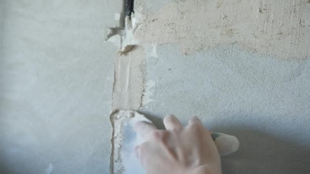 Нерозпізнаний чоловік оштукатурить бетонну стіну дротом — стокове відео