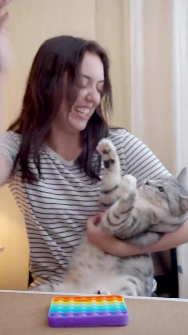 Młoda kobieta bawiąca się kotem w pop — Wideo stockowe
