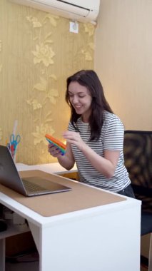 Kadın görüntülü konuşma yapıyor ve pop müziğini oyuncak olarak gösteriyor. Dikey video