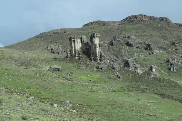 Formacion rocosa en medio del campo contrasta con el cielo de fondo