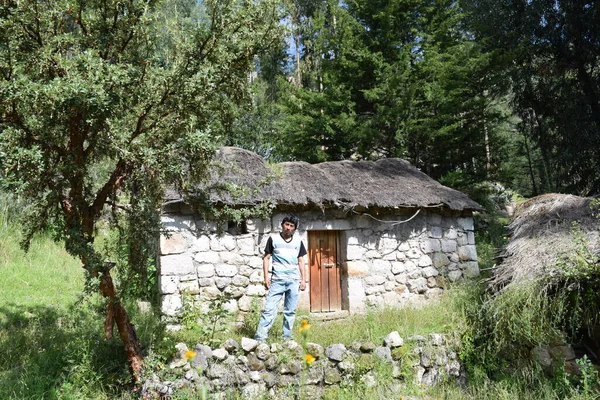 Joven posando on la puerta de su casa en el campo