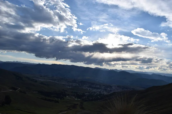 Luz del sol traspasando las nubes y alumbrando a centro poblado