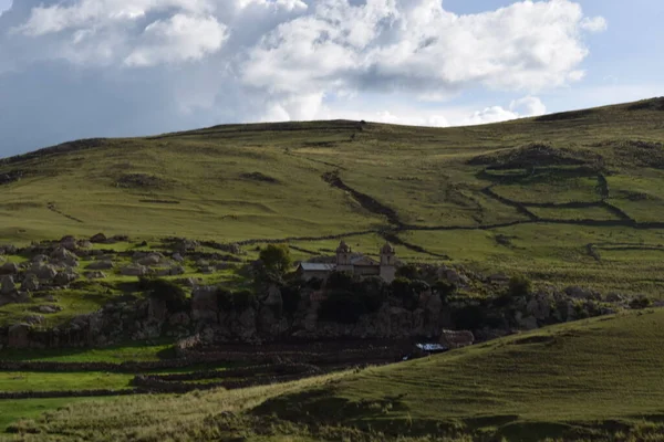 Iglesia aislada en el campo contrasta con las montaas y el cielo