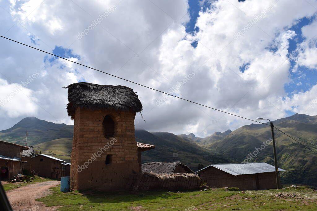 Torre de vigilancia en medio del campo contrasta con un cielo azul y las nubes blancas