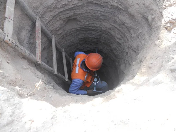 İşçi derin kazılarda toprak araştırması yapıyor