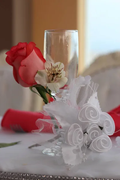 Copa de Cristal en primer plano, dekorada con flores rojas y cintas blancas para el uso de la novia como parte del brindis de los recien casados. Imagen ideal para promocionar dekoraciones y menaje.