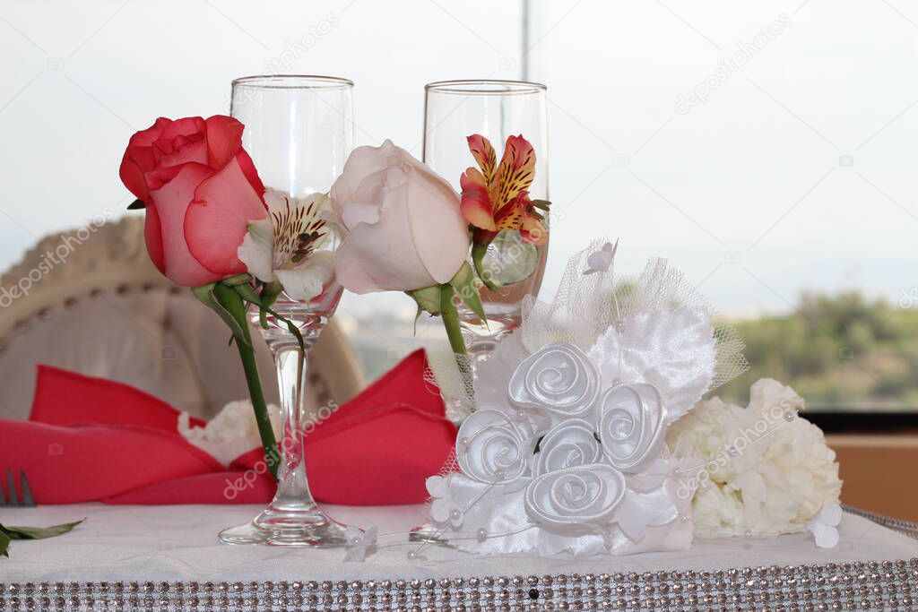 Copas de los recien casados en primer plano, decoradas con flores cintas para el brindis. Imagen ideal para promocionar decoraciones y menaje.
