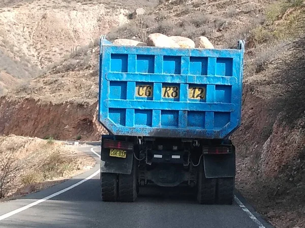 Mavi zıpzıp taşıyan bahşişçi Gabion inşaatı için küçük bir yolculuk yolunda taş taşıyor. Caraveli Arequipa - Peru