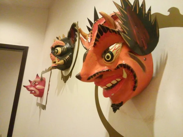 Diversas mascaras en que representan al diablo en formas humanizadas y de bestias, utilizadas en danzas de pueblos oriundos del Peru, colgadas como exposicion en un muro.