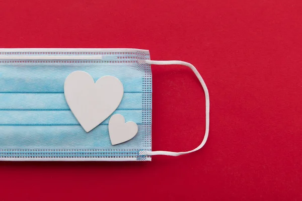 Día de San Valentín covid-19 fondo con máscara quirúrgica y corazones de amor blanco — Foto de Stock