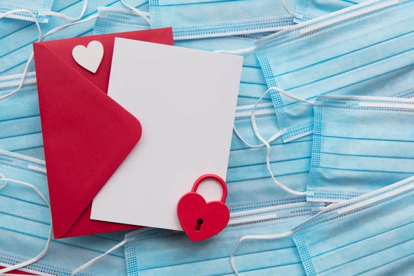 Carta de amor en blanco del día de San Valentín sobre las máscaras faciales del virus covid — Foto de Stock