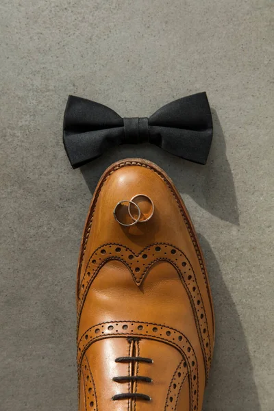 Подготовка к свадьбе лежала ровно с кольцами галстук-бабочка и обувь — стоковое фото