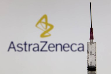 OXFORD, İngiltere - Şubat 2020: Astrazeneca logosu önünde Covid aşı şırıngası