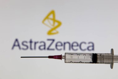 OXFORD, İngiltere - Şubat 2020: Astrazeneca logosu önünde Covid aşı şırıngası