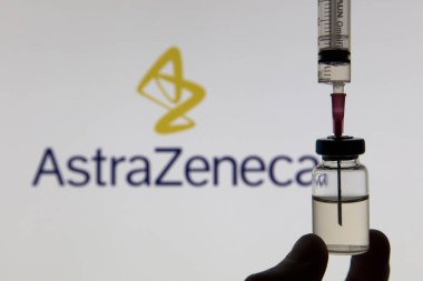OXFORD, İngiltere - Şubat 2020: Astrazeneca logosu önünde Covid aşı şırıngası