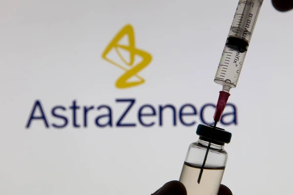 OXFORD, UK - February 2020: Astrazeneca 로고 앞에 있는 Covid 백신 주사기 — 스톡 사진