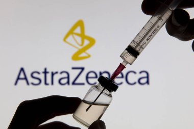 OXFORD, İngiltere - Şubat 2020: Astrazeneca logosu önünde Covid aşı şırıngası
