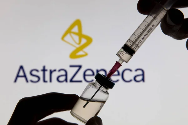 OXFORD, UK - February 2020: Astrazeneca 로고 앞에 있는 Covid 백신 주사기 — 스톡 사진