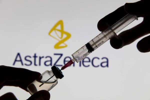 OXFORD, İngiltere - Şubat 2020: Astrazeneca logosu önünde Covid aşı şırıngası — Stok fotoğraf