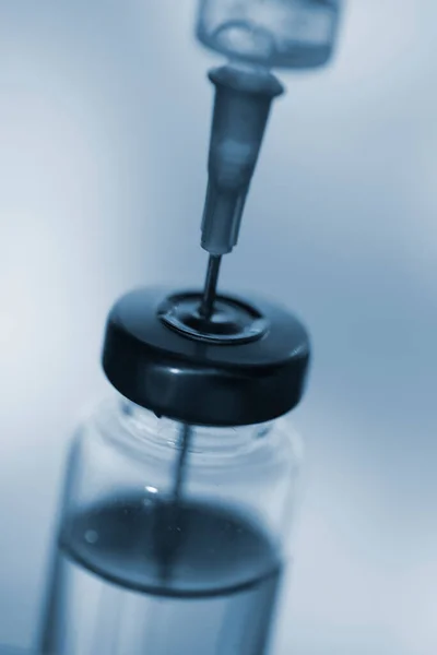 Acercamiento de una aguja de inyección médica en una dosis del vial de vacuna — Foto de Stock
