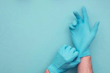 Doktorlar bir çift mavi koruyucu ameliyat eldiveni giyiyorlar..