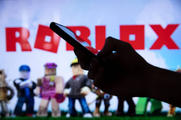 LONDON, Großbritannien - März 2021: Person mit Smartphone mit Roblox-Spiellogo — Stockfoto