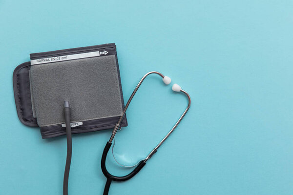 Blood pressure test monitor with a stethoscope on a blue background