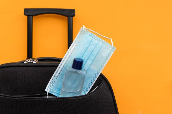 Cestovní kufr zabalený s obličejovou maskou a dezinfekcí rukou — Stock fotografie