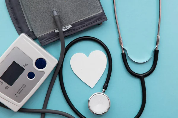 青い背景に聴診器付き血圧検査モニター — ストック写真