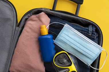 Çanta küresel koronavirüs salgını sırasında yaz tatili için hazırlanıyor.