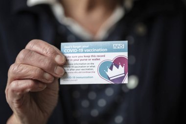 Londra, İngiltere - Nisan 2021. NHS Covid-19 aşı kaydını tutan kişi.