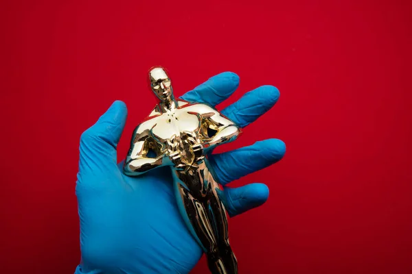 Nagroda filmowa i rozrywkowa przyznawana przez kogoś w rękawiczkach ochronnych — Zdjęcie stockowe